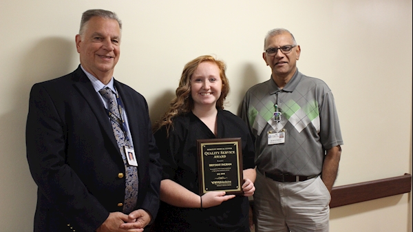 WVU Medicine Berkeley Medical Center’s July Quality Service Award winner is pictured receiving her award.  Left to right: President/CEO Anthony P. Zelenka, QSA Winner Brittany Ingram and Radiology Director Selwyn Persad. 